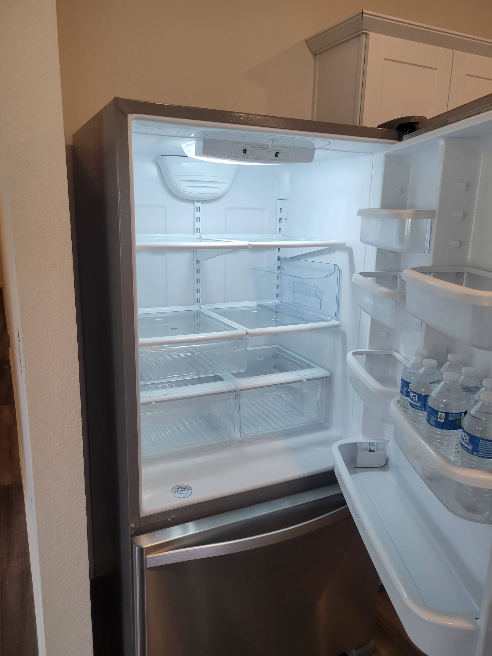 Open stainless steel refrigerator filled with shelves and door storage.