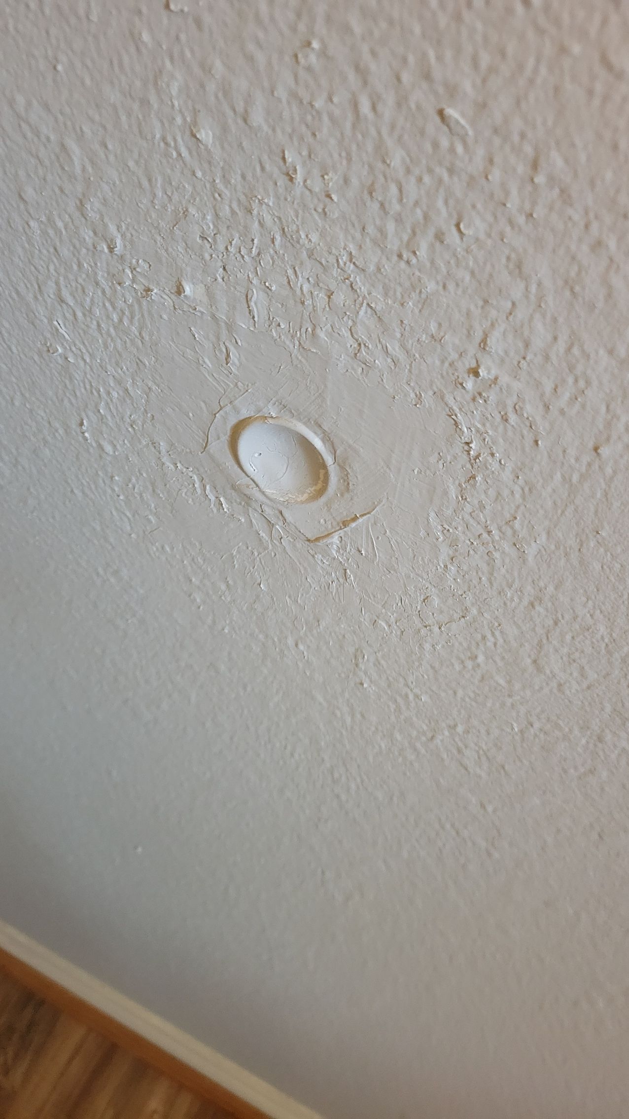 Off-white ceiling with peeling paint around a recessed light fixture.