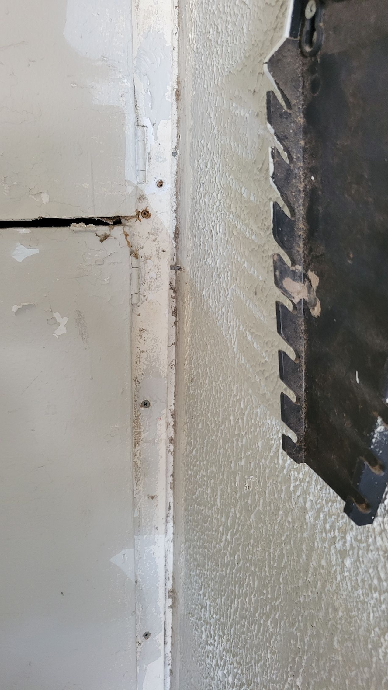 Close-up view of a wall section and a notched trowel, suggesting drywall installation or repair.