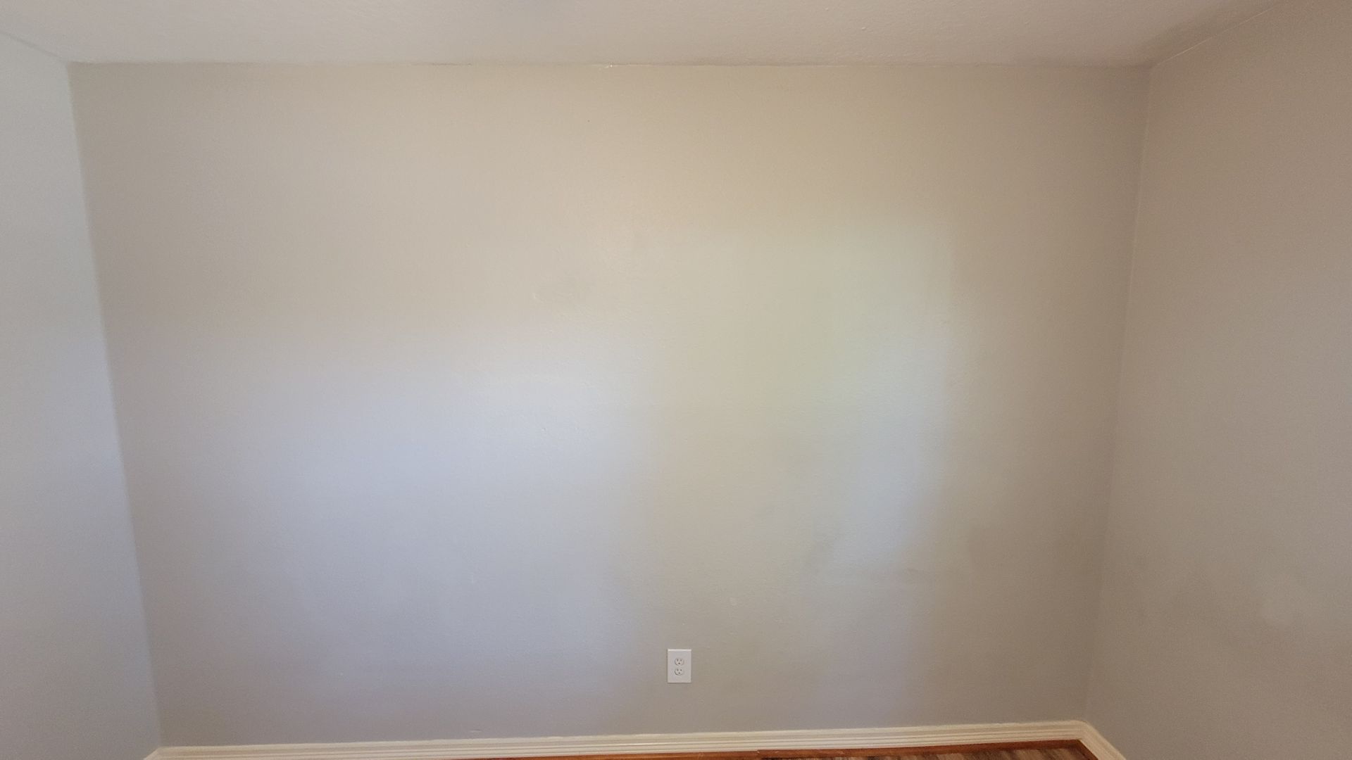 A light gray interior wall with an electrical outlet near the floor.