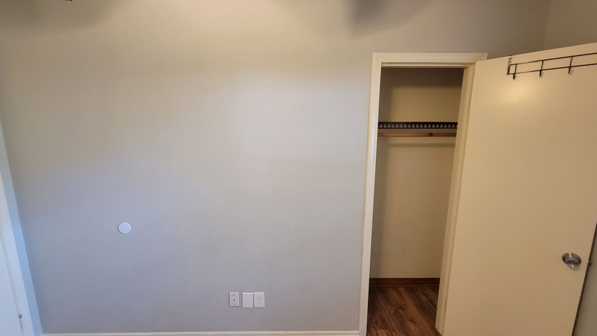 Empty room with gray walls and open closet.