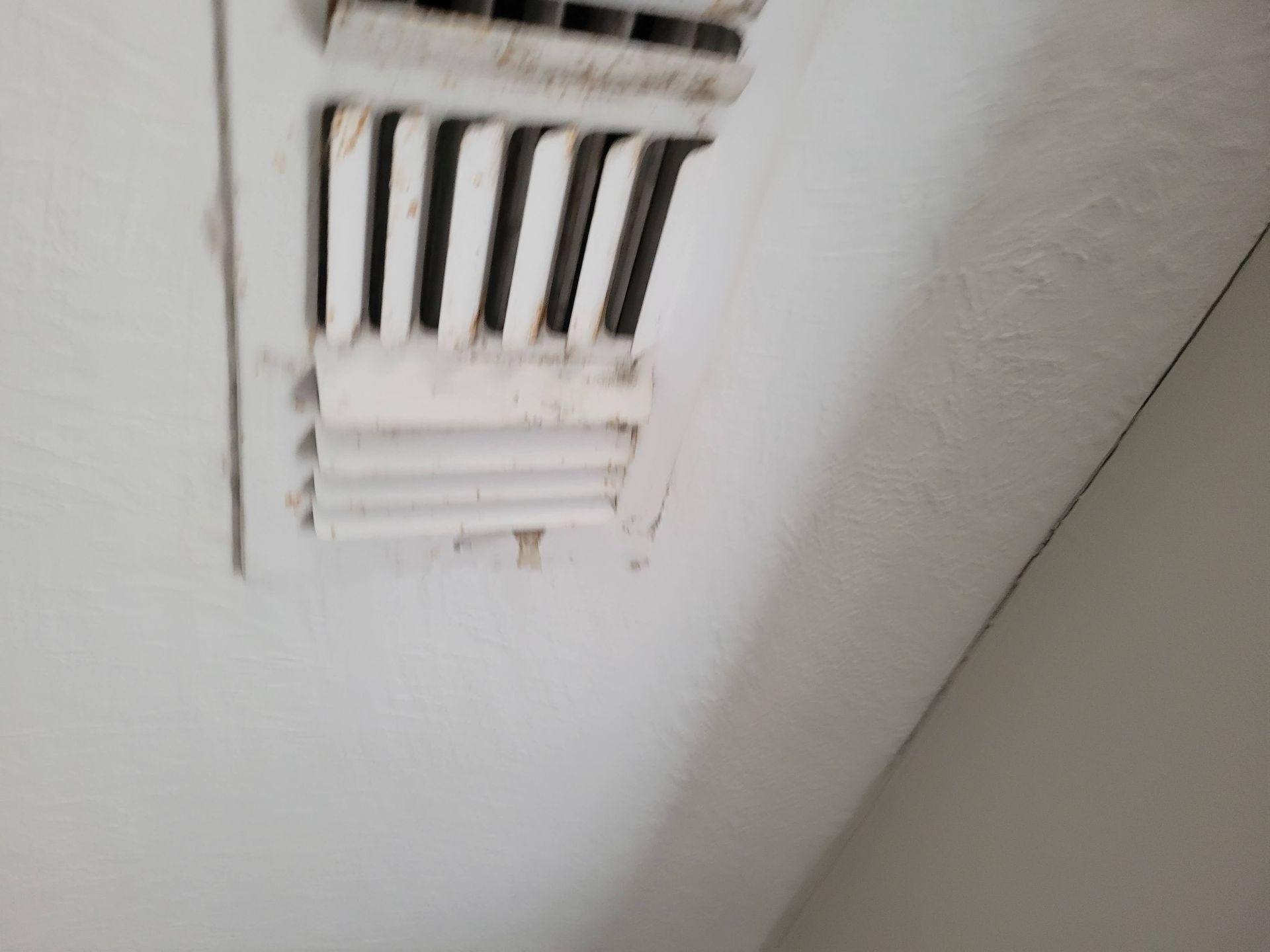 Dirty air vent on a white ceiling.
