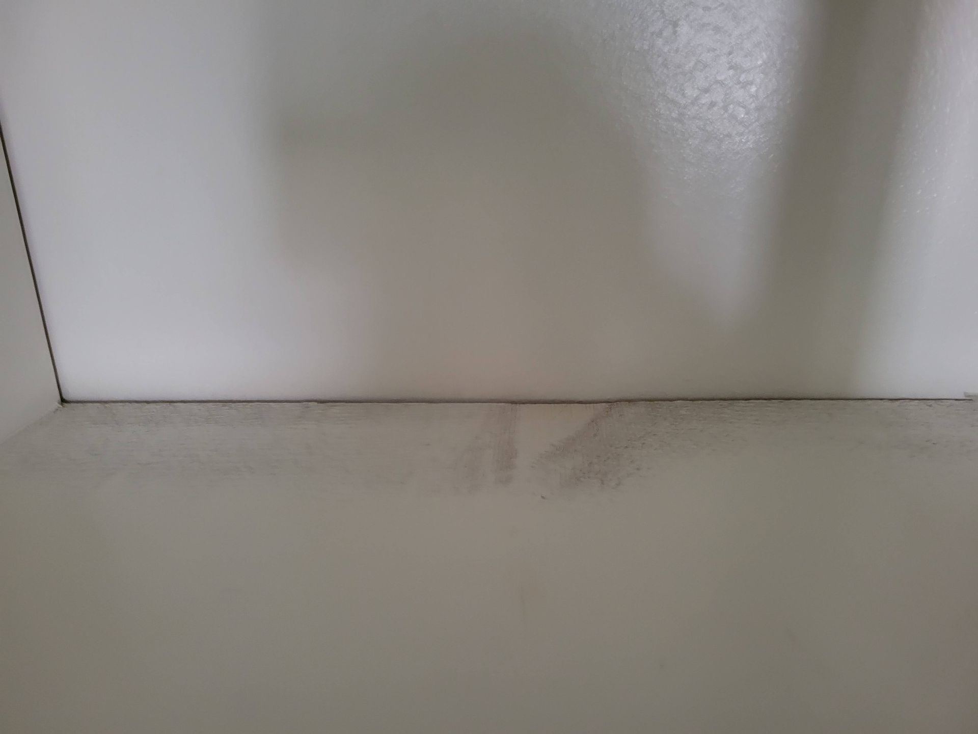 White walls with a darker, stained area near the base.