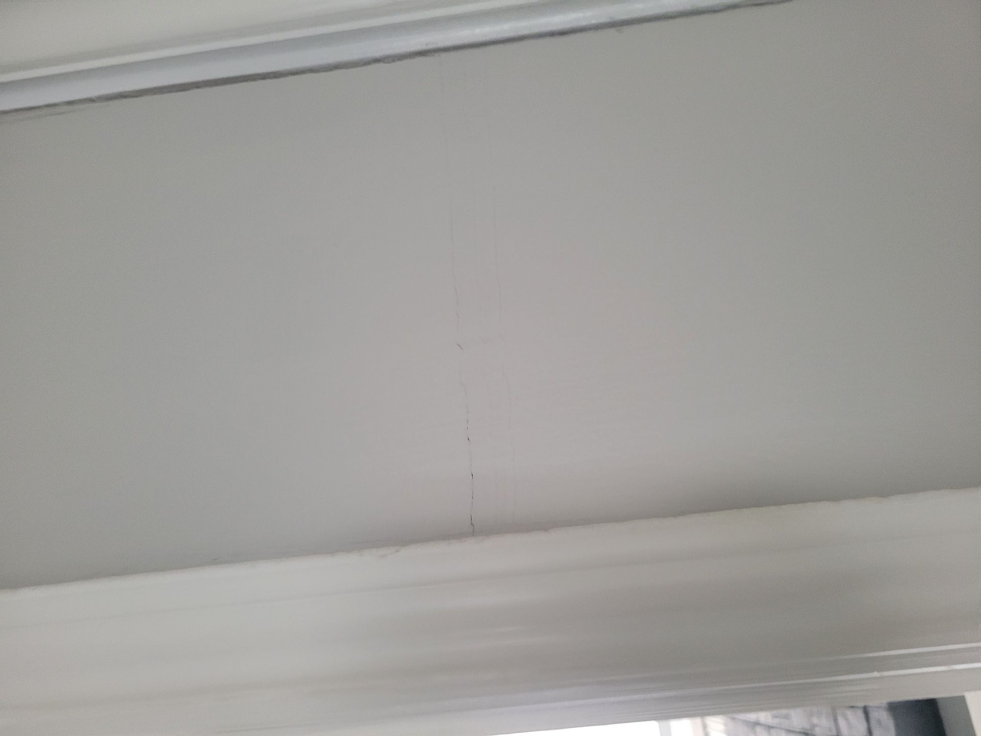 Ceiling with a visible vertical crack and decorative trim.