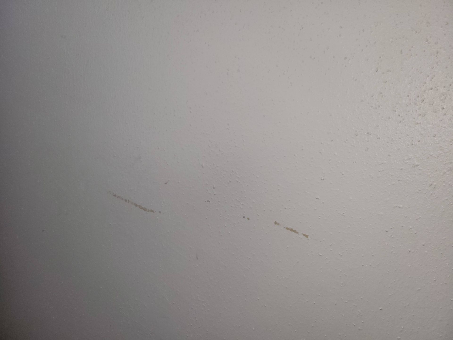 Scratches on a white wall.