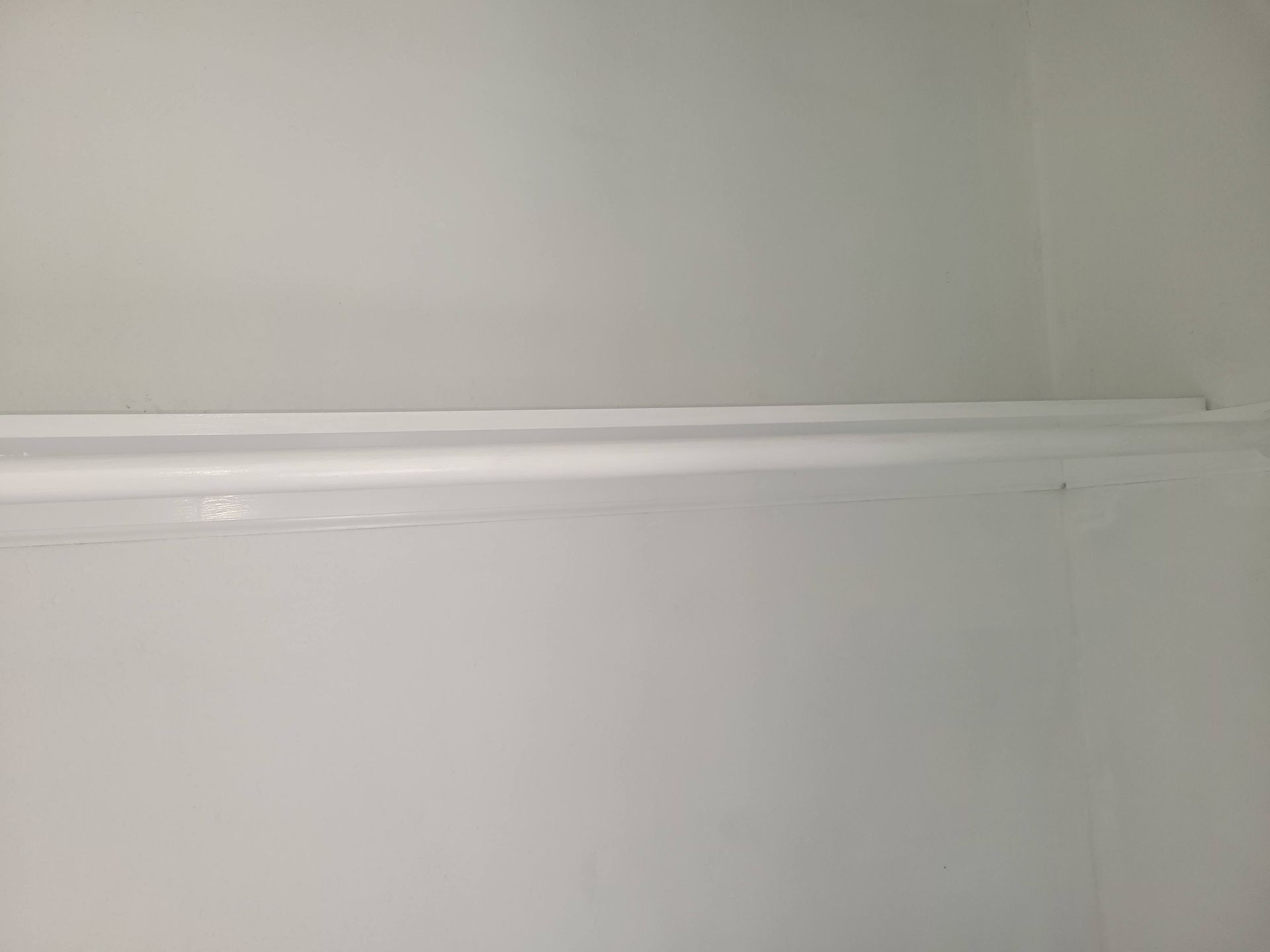 White interior with a horizontal shelf dividing the frame, all painted white.