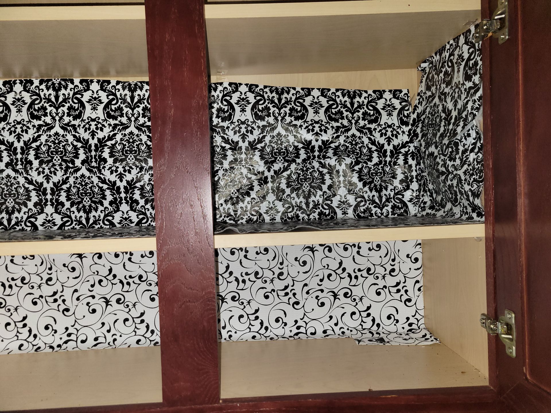 Cabinet interior lined with black and white patterned paper.