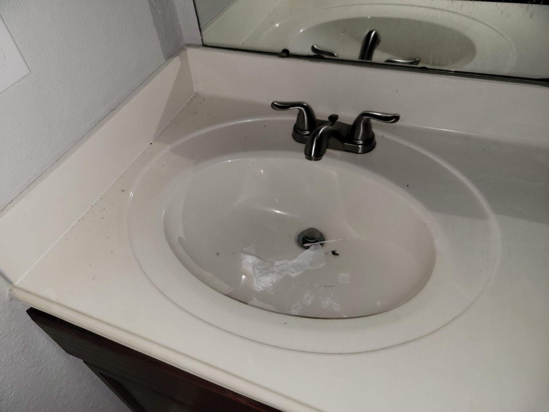 Oval bathroom sink with faucet and mirror reflection.
