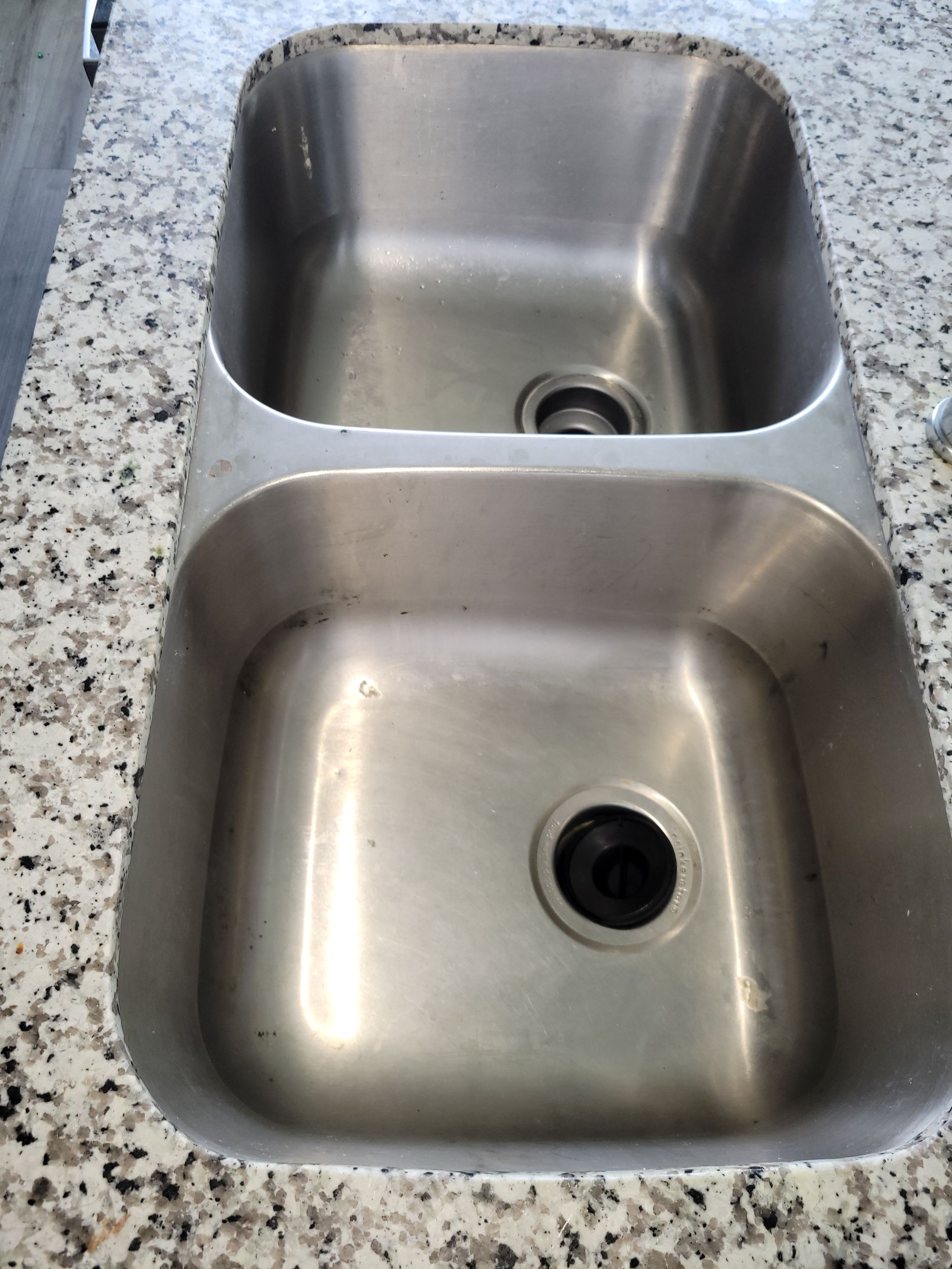 Stainless steel double kitchen sink in granite countertop.