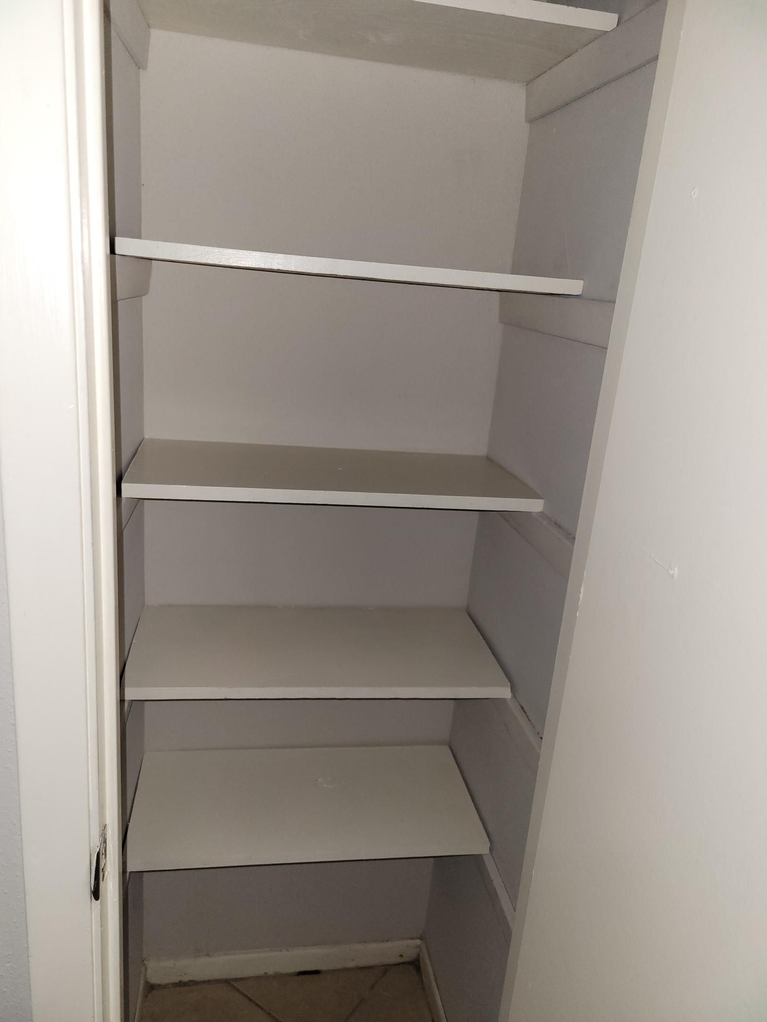 Empty white closet with four shelves.