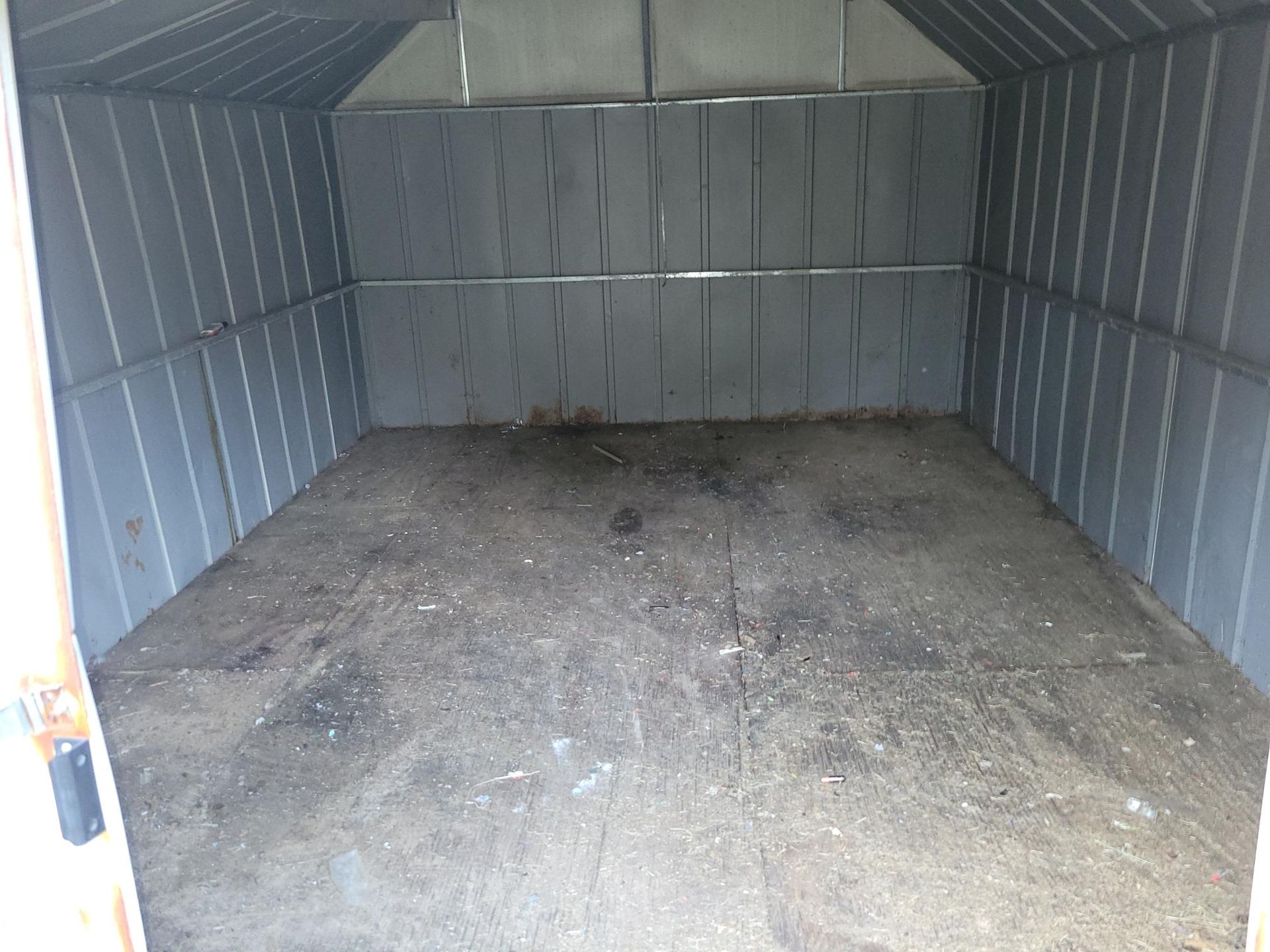 Empty, gray storage shed interior; dirt floor, metal walls and ceiling.