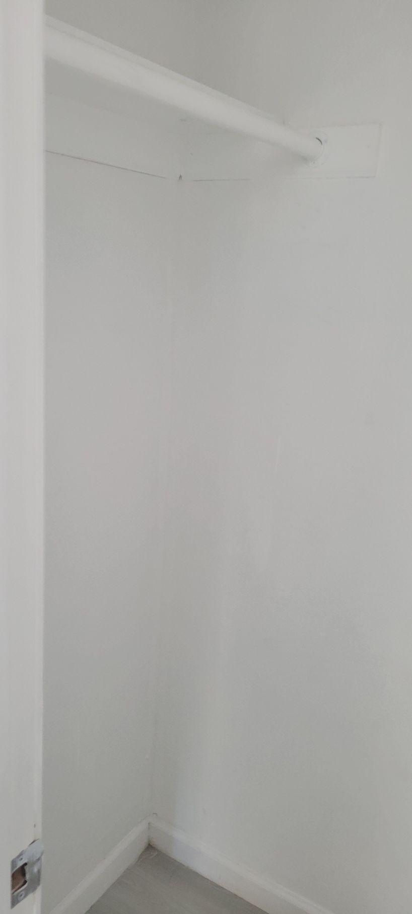 Empty white closet with a shelf. The floor is light gray.