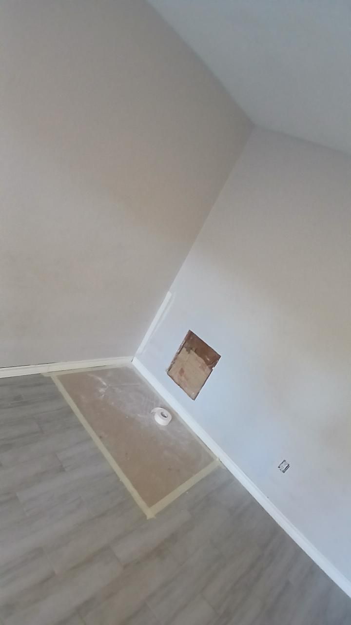 Interior room with beige walls, light wood-look floor, and a rectangular hole in the wall.