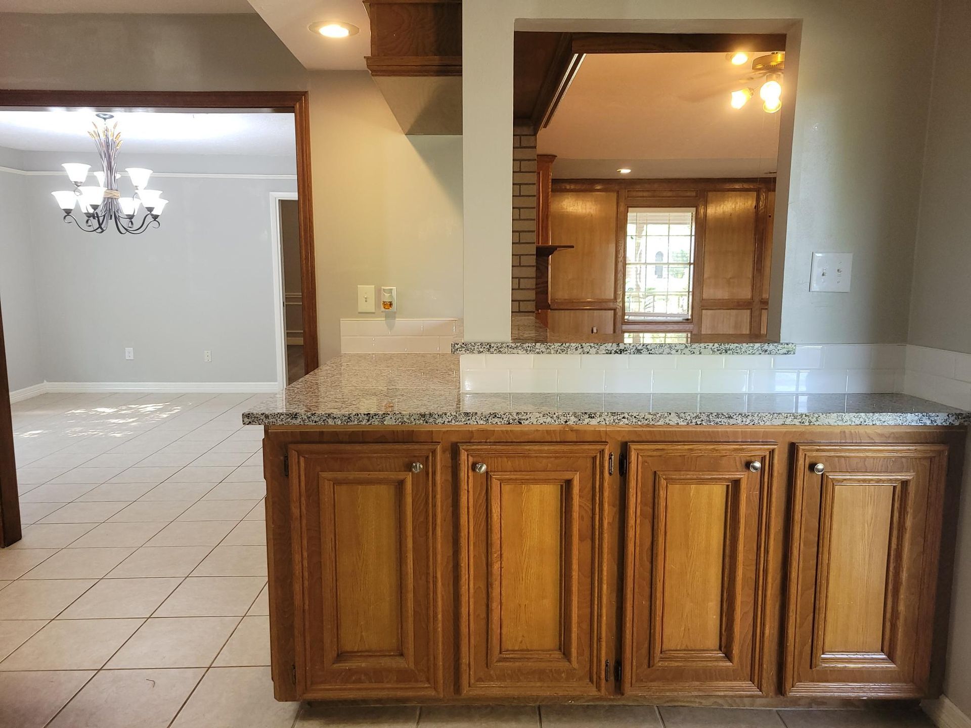 Kitchen with brown cabinets, granite countertop, and doorway to a dining room.