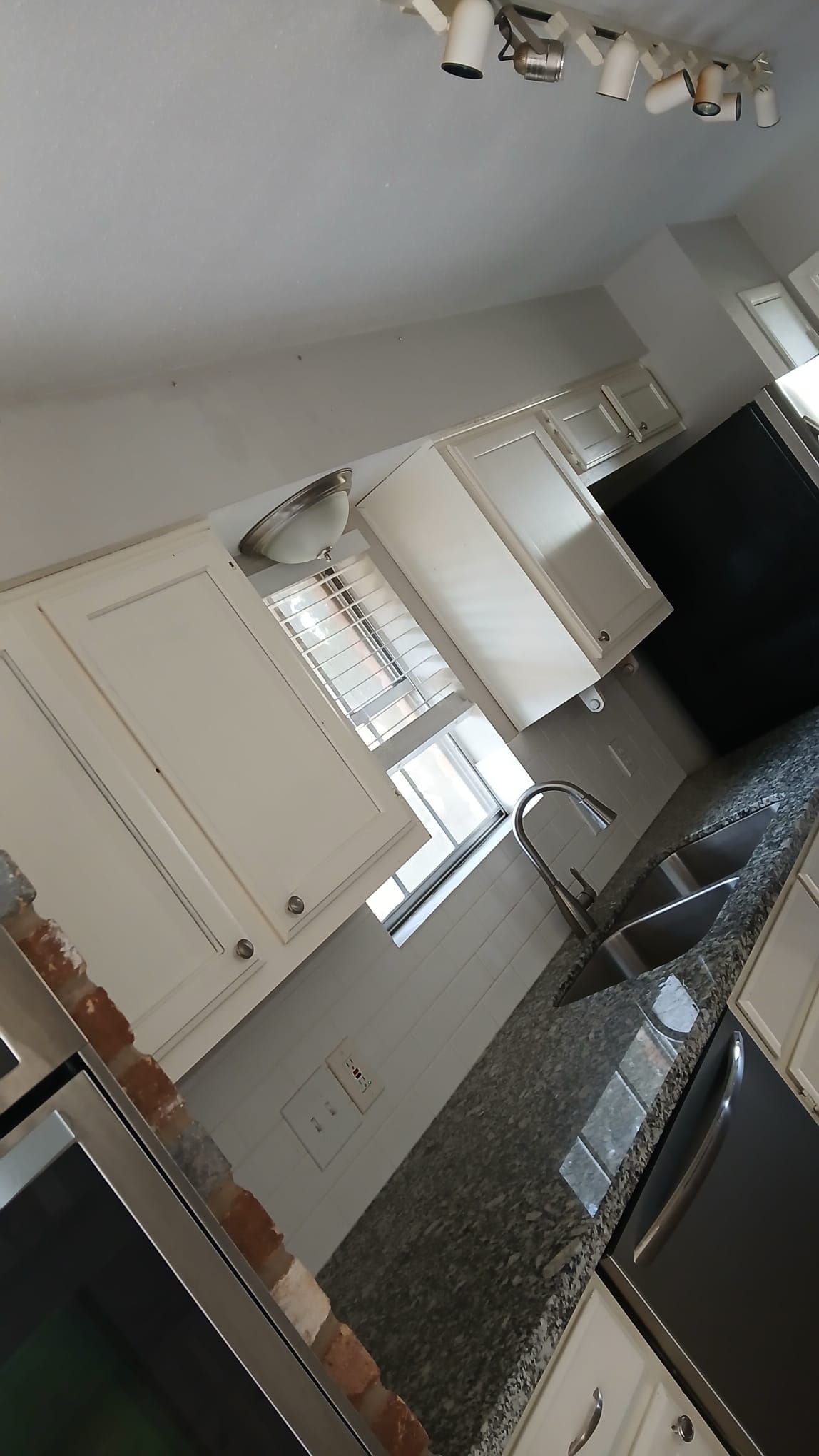 Kitchen with white cabinets, dark countertops, and stainless steel appliances.
