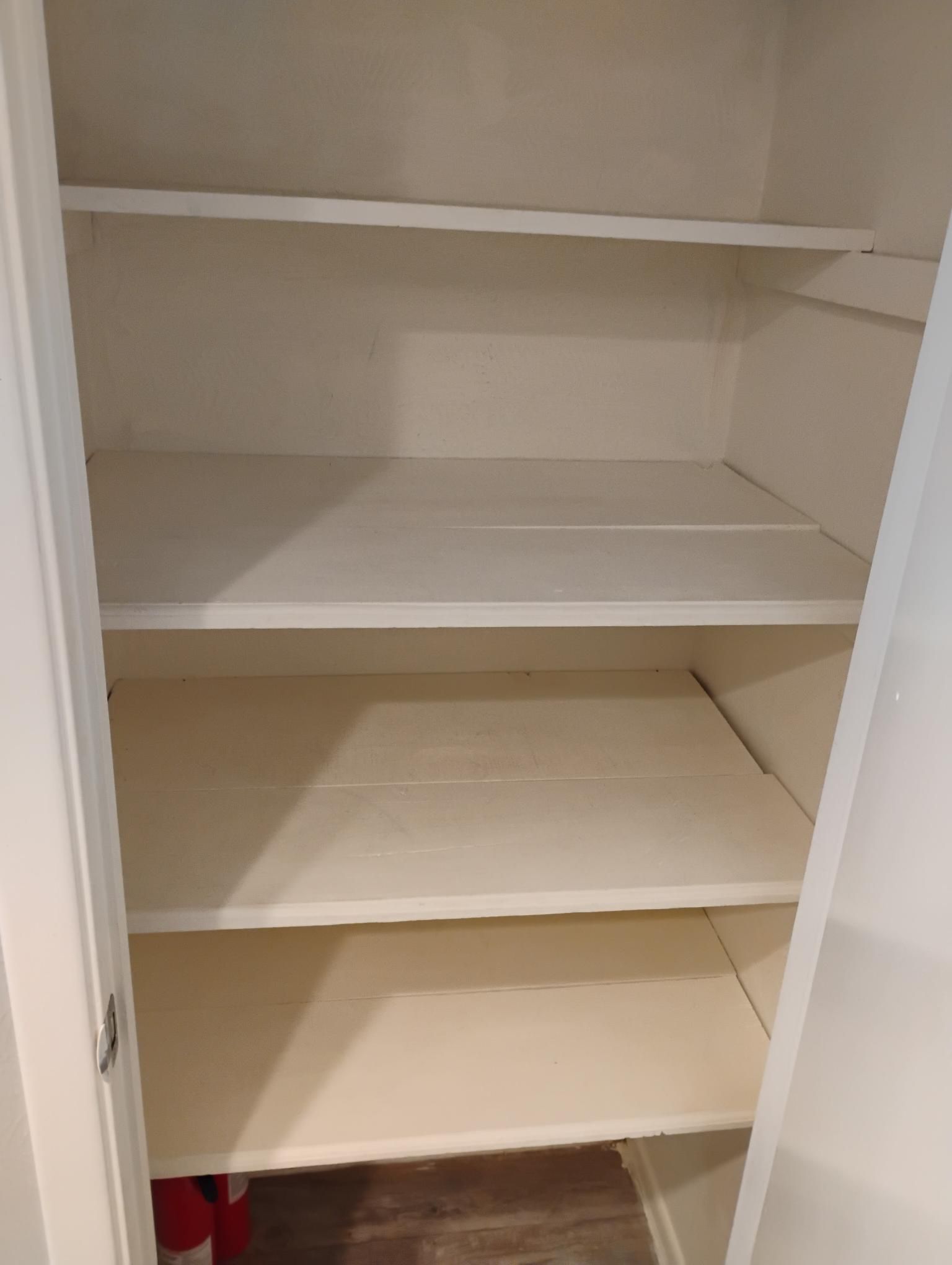 Empty white closet with four shelves.