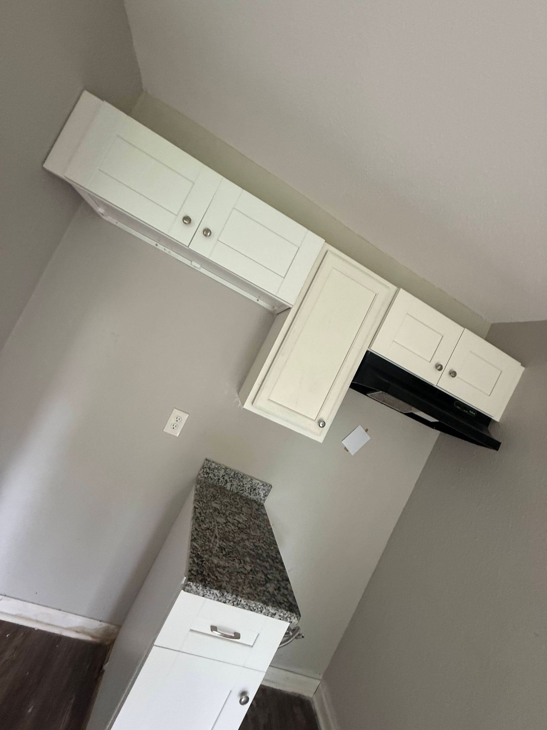 White kitchen cabinets with granite countertop.