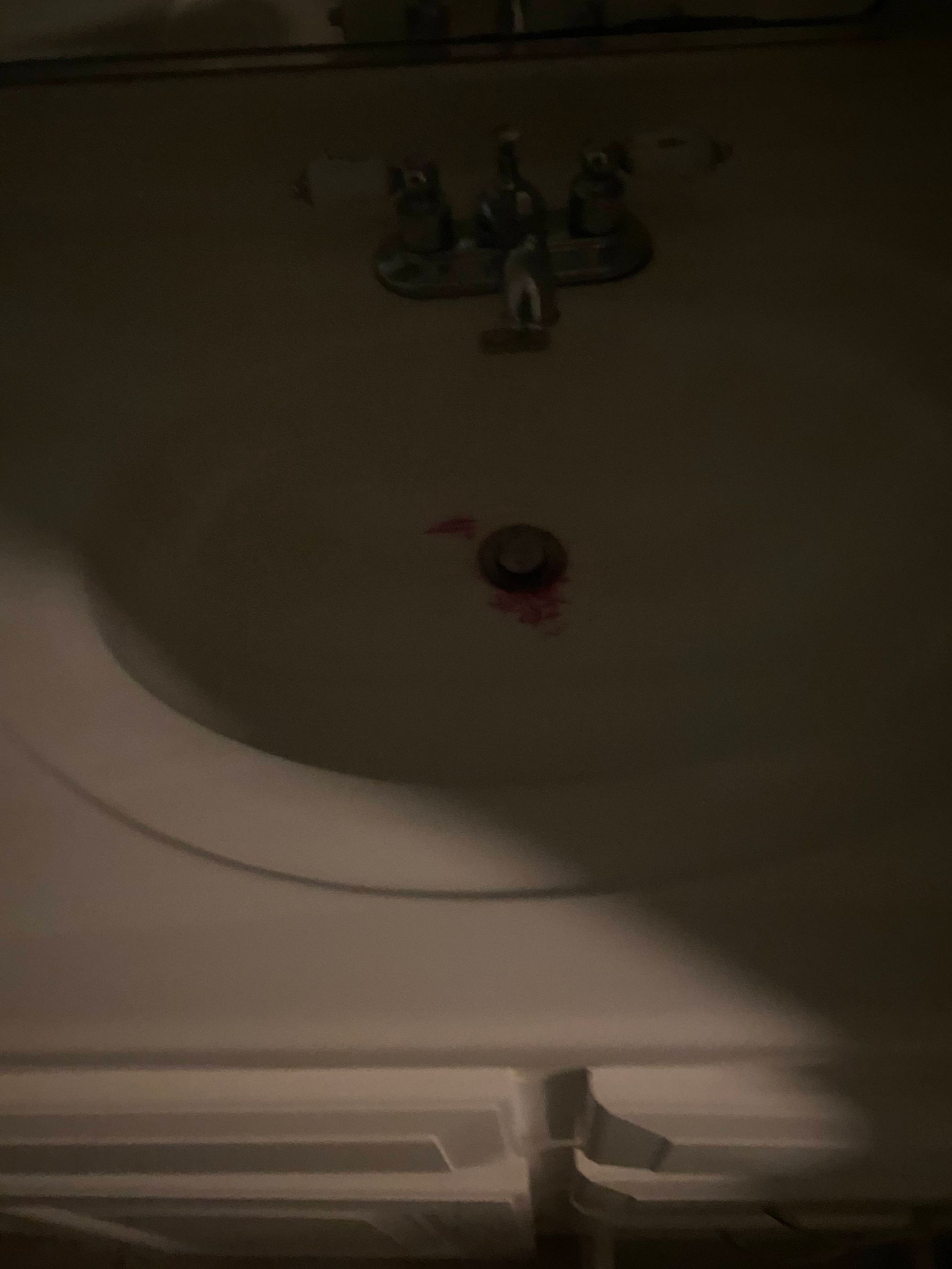 White bathtub with faucet and drain in dim lighting.