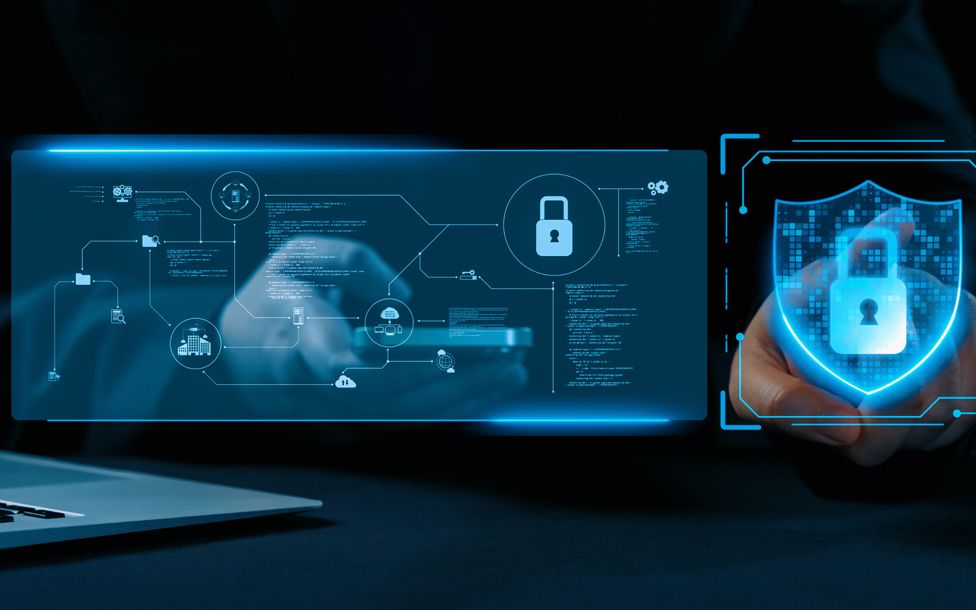 A person is holding a shield with a padlock on it in front of a laptop.