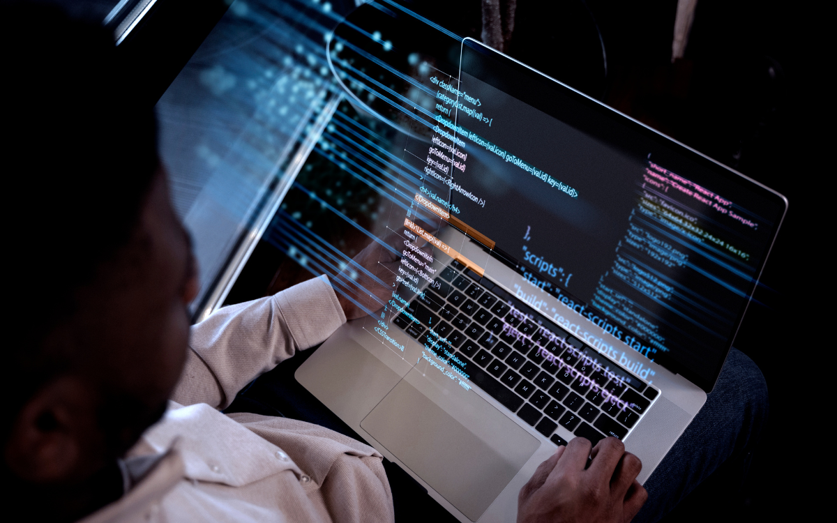 A man is sitting in front of a laptop computer.