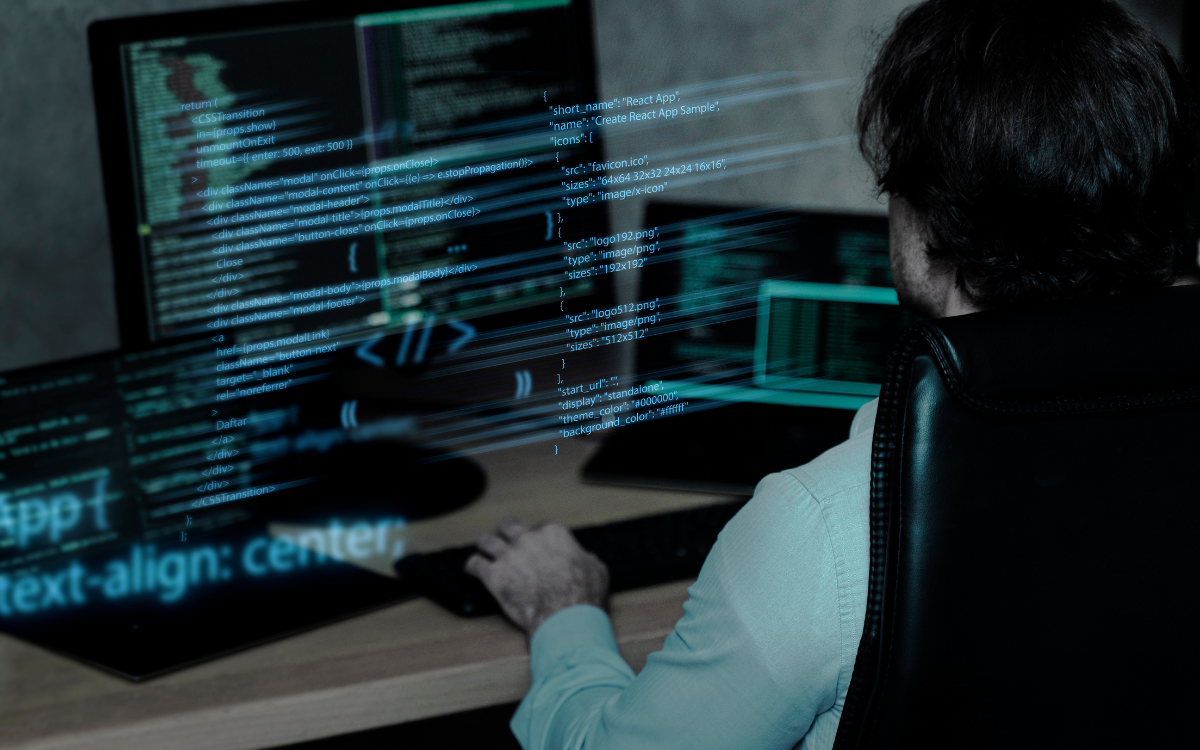 A man is sitting at a desk working on a computer.