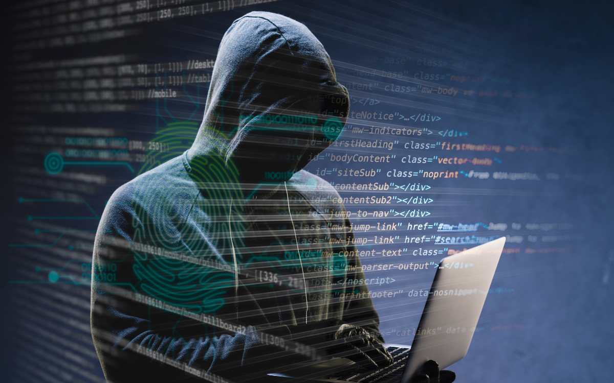 A man in a hoodie is using a laptop computer.