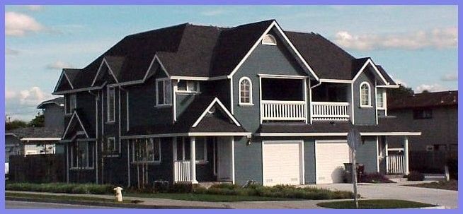 Blue house with white trim, dark roof, and two garage doors. Set against a blue sky.