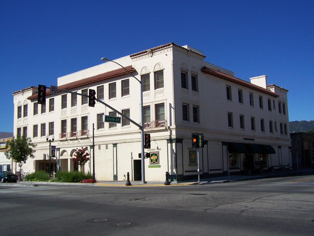 Two-story house with a gray exterior, brown accents, white garage door, and a small porch.