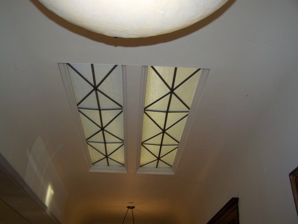 Two rectangular skylights with a geometric black pattern in a white ceiling.