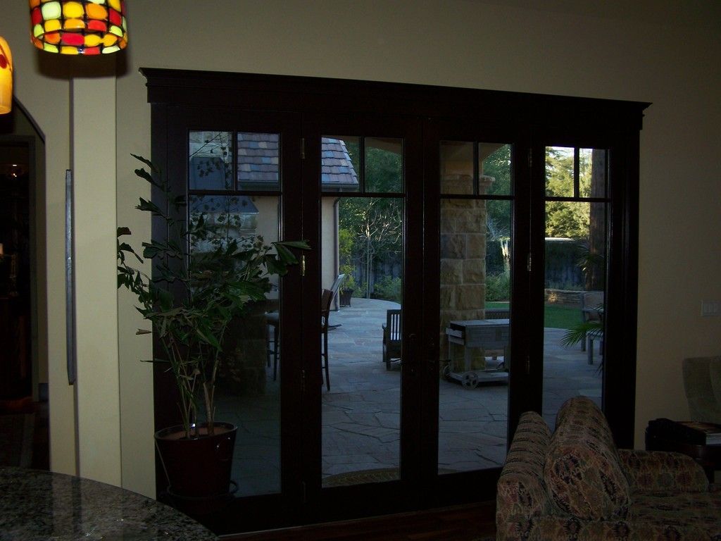 Dark-framed door with ironwork grapes and a patterned background.