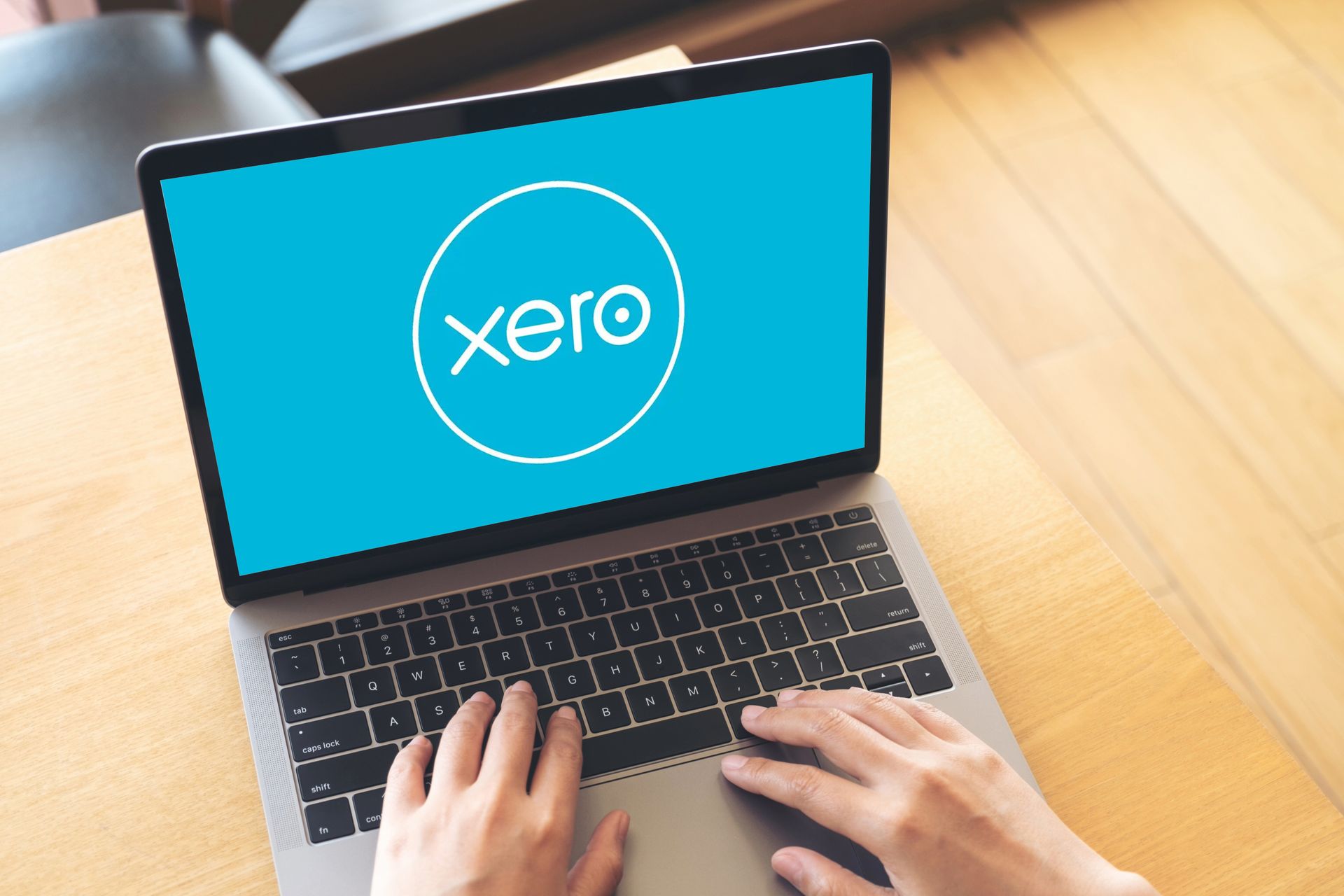 Person typing on laptop with Xero accounting software logo on screen.