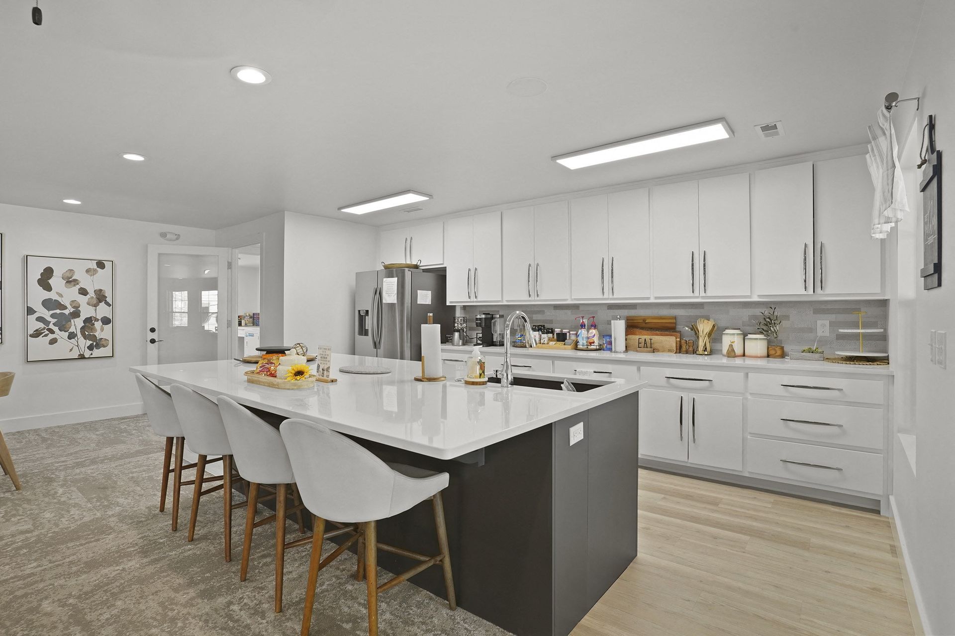 A modern kitchen with a large island and white cabinets.