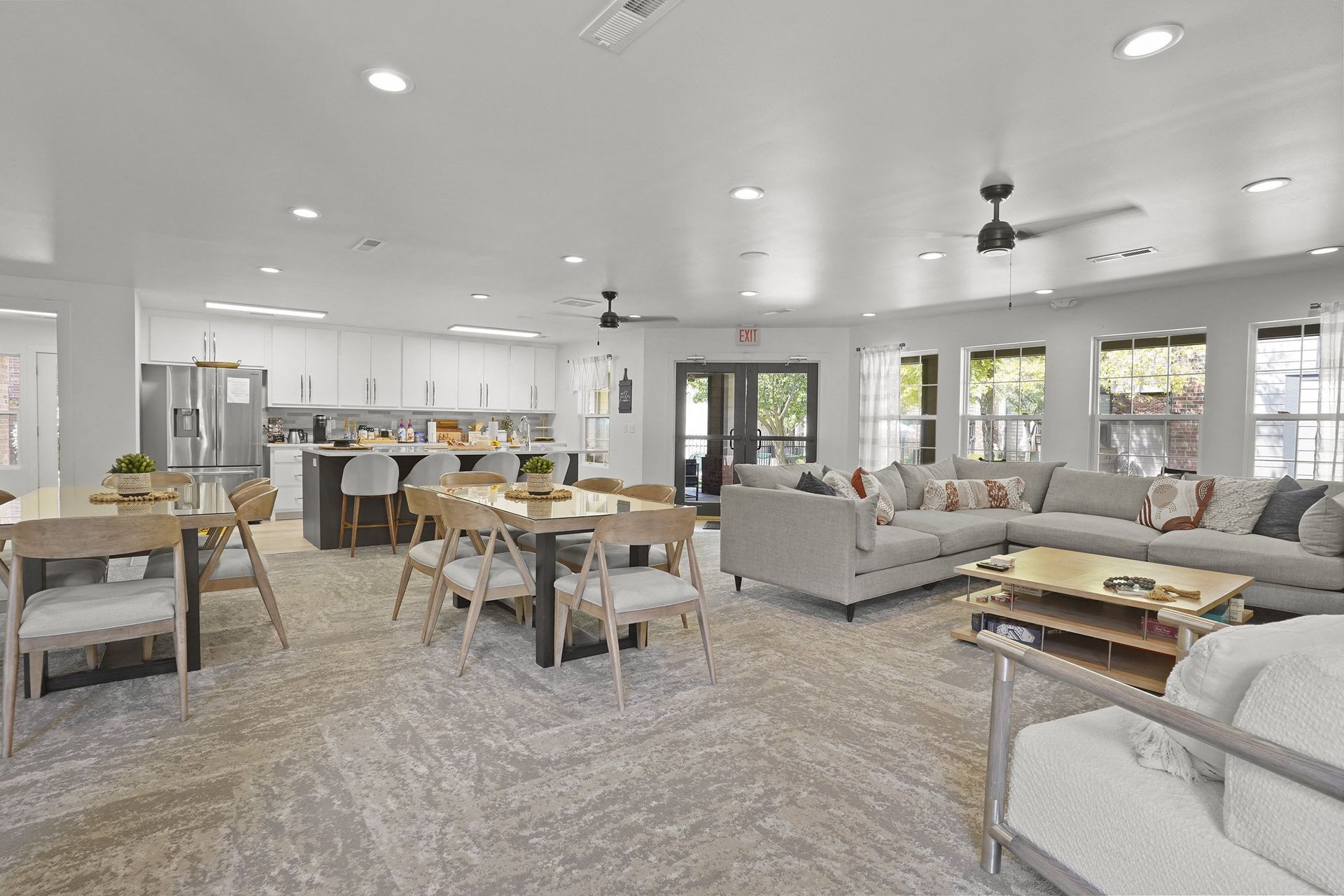 A modern open-concept living room with a dining area and kitchen in the background.