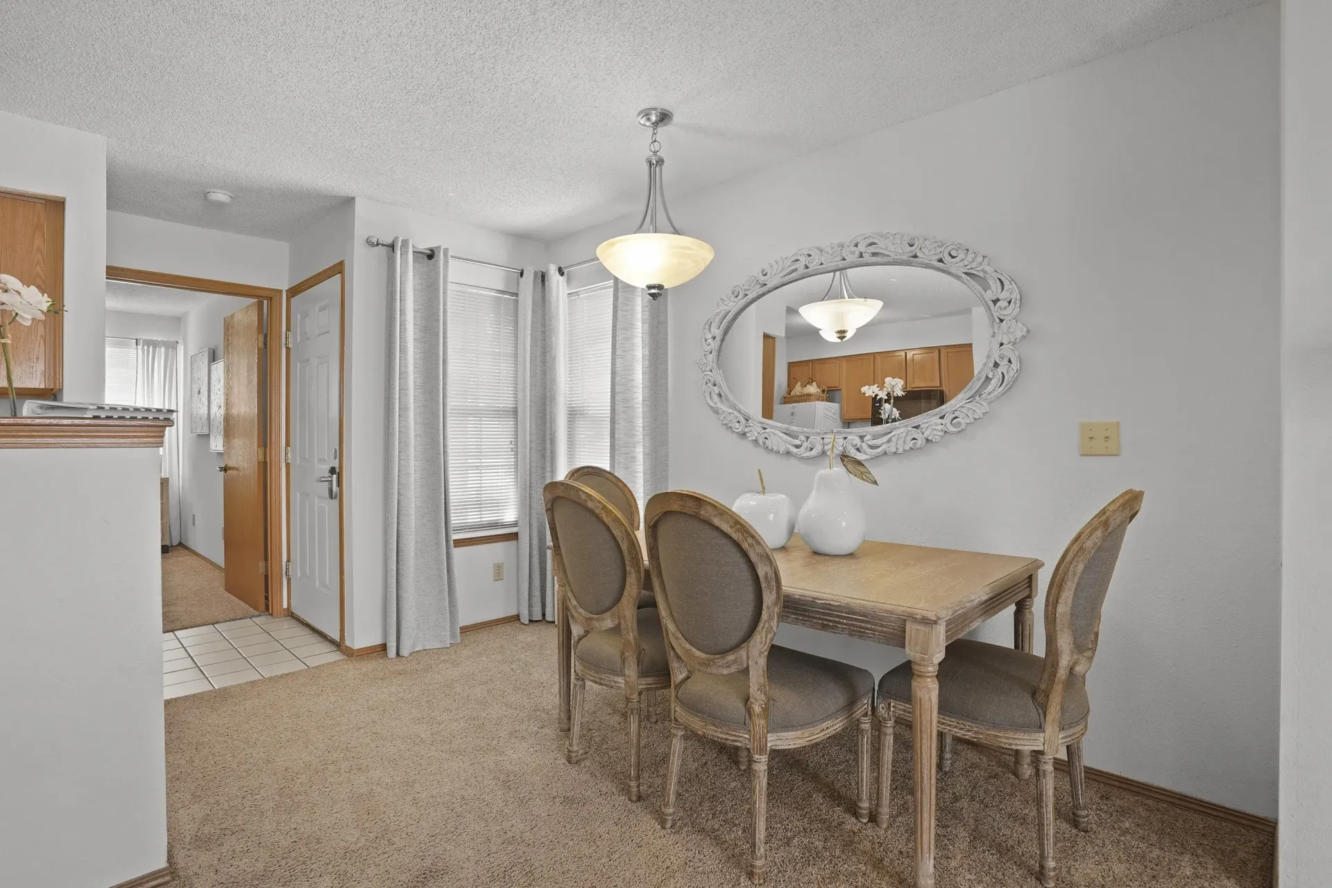 A dining room with a table and chairs.