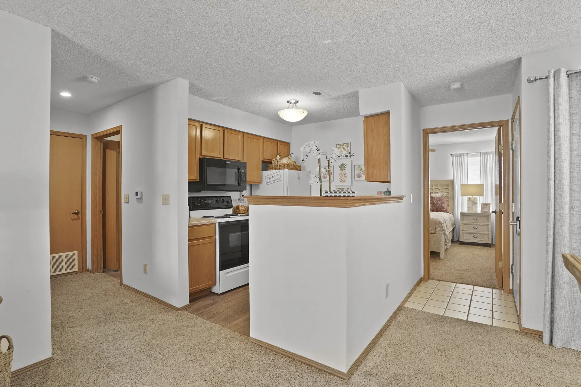 A kitchen with white appliances and wooden cabinets.