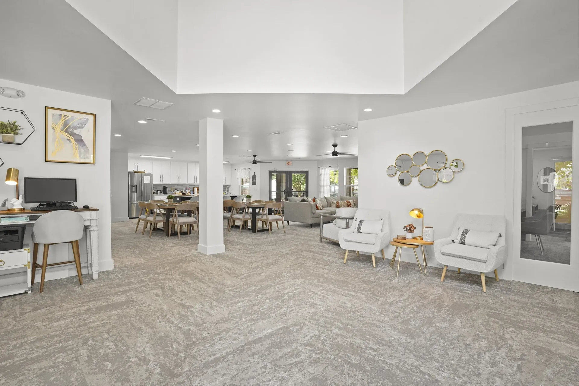 A spacious living room with a grey carpet and white furniture.