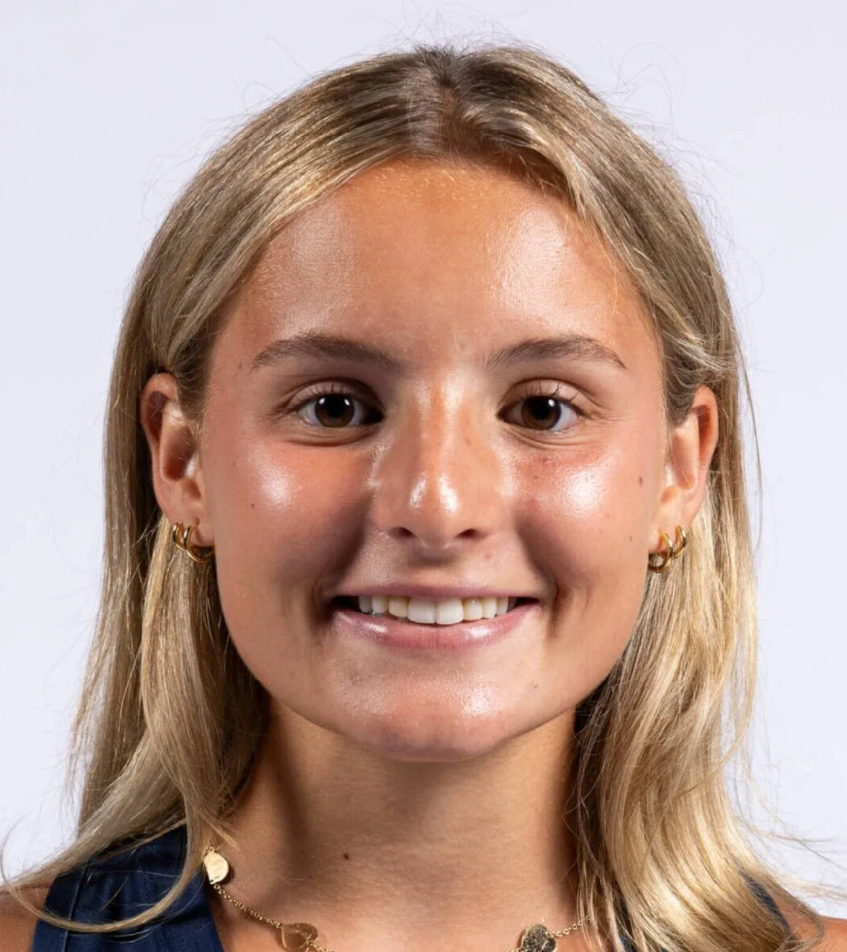 Smiling person with blonde hair against a light background