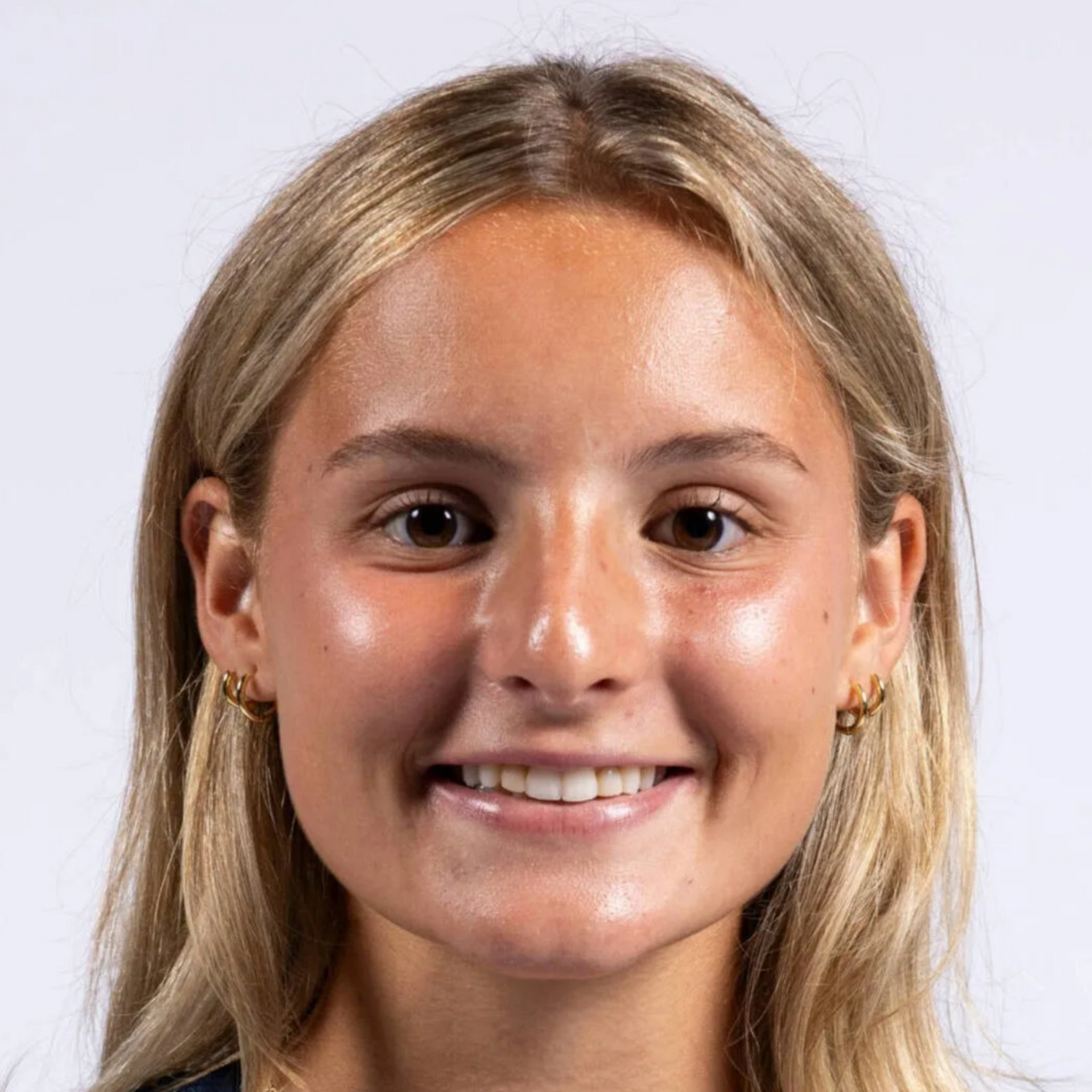 Smiling person with blonde hair against a light background