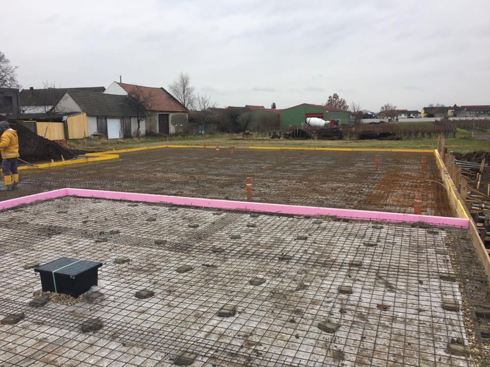 Baustelle: Fundament mit Bewehrungsgitter, Dämmung und Schalung, vorbereitet für den Betoniervorgang.