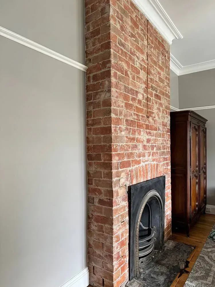 A Living Room With a Fireplace and a Brick Wall — Chandolin Construction in Bathurst, NSW