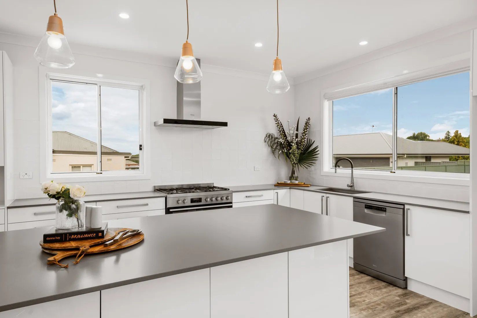 A Kitchen With White Cabinets , Stainless Steel Appliances and a Large Island — Chandolin Construction in Bathurst, NSW