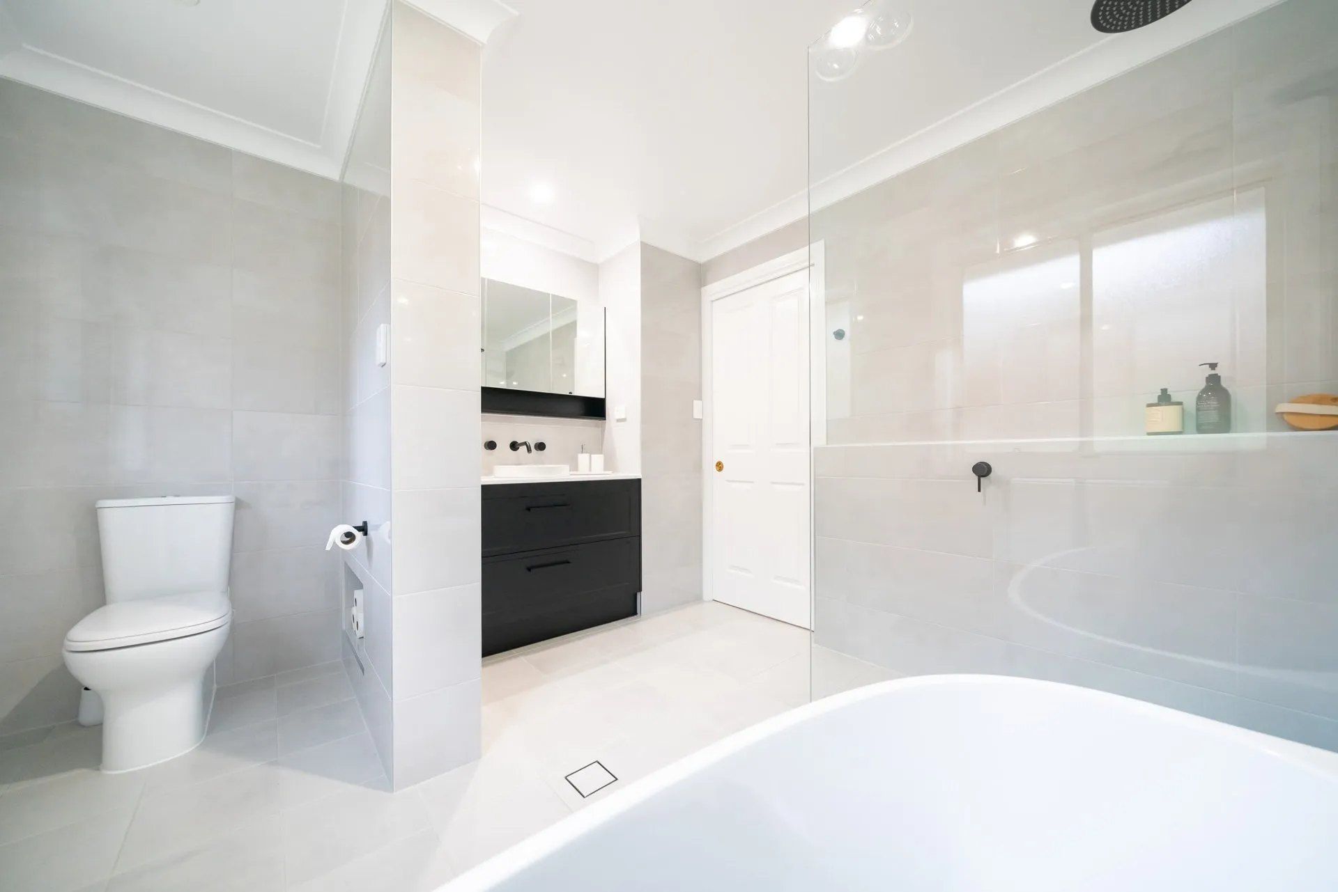 A Bathroom With a Toilet , Sink , and Bathtub — Chandolin Construction in Bathurst, NSW