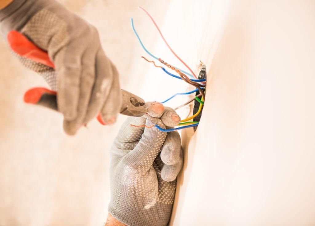 A person is cutting a wire with a pair of pliers.