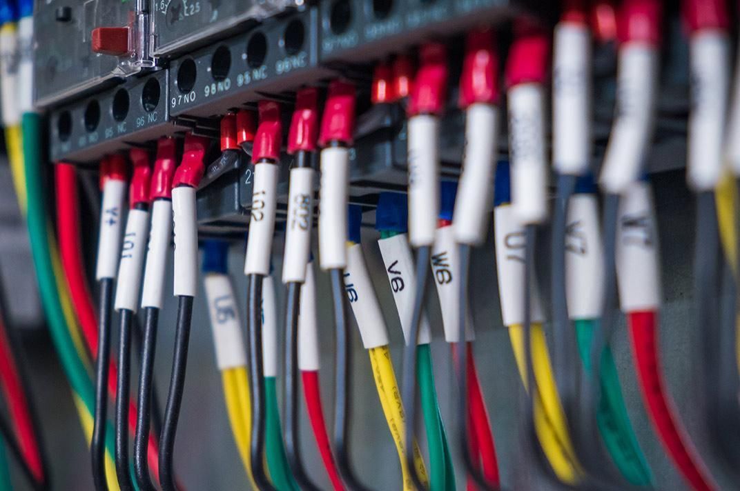 A close up of a bunch of wires in a electrical box.