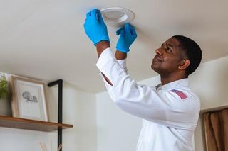 a mr sparky electrician fixing a ceiling light