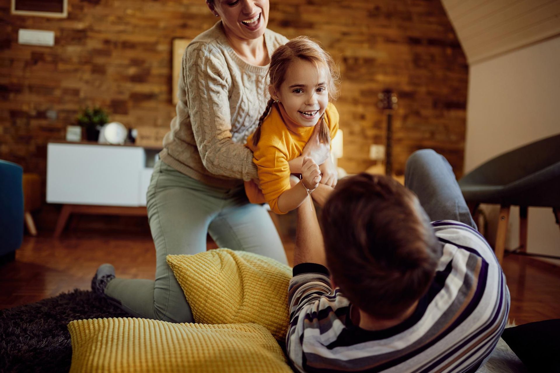 A family is playing with a little girl in a living room.
