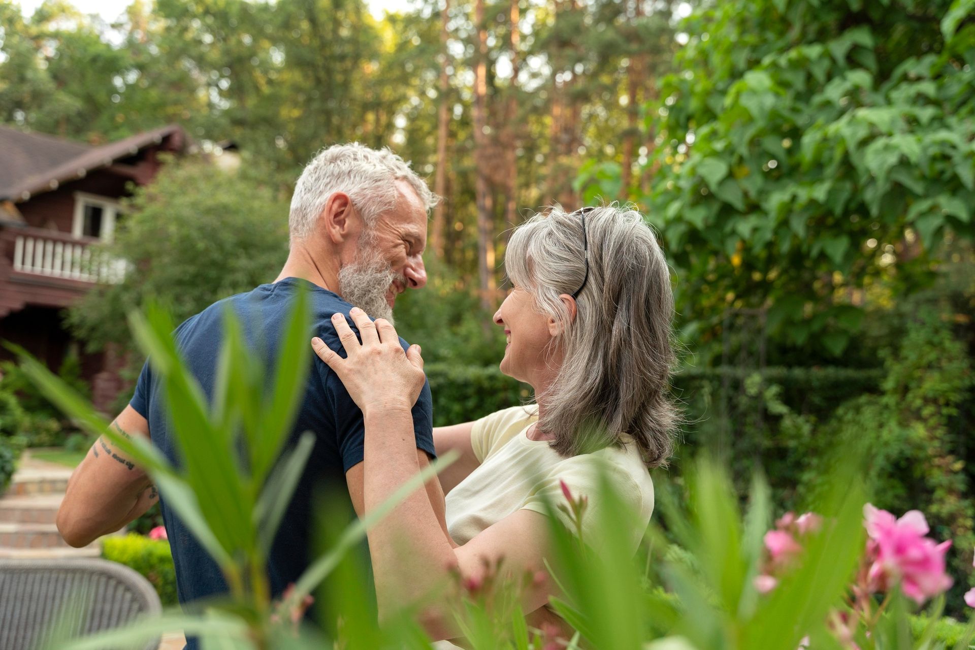 A man and a woman are dancing in a garden.
