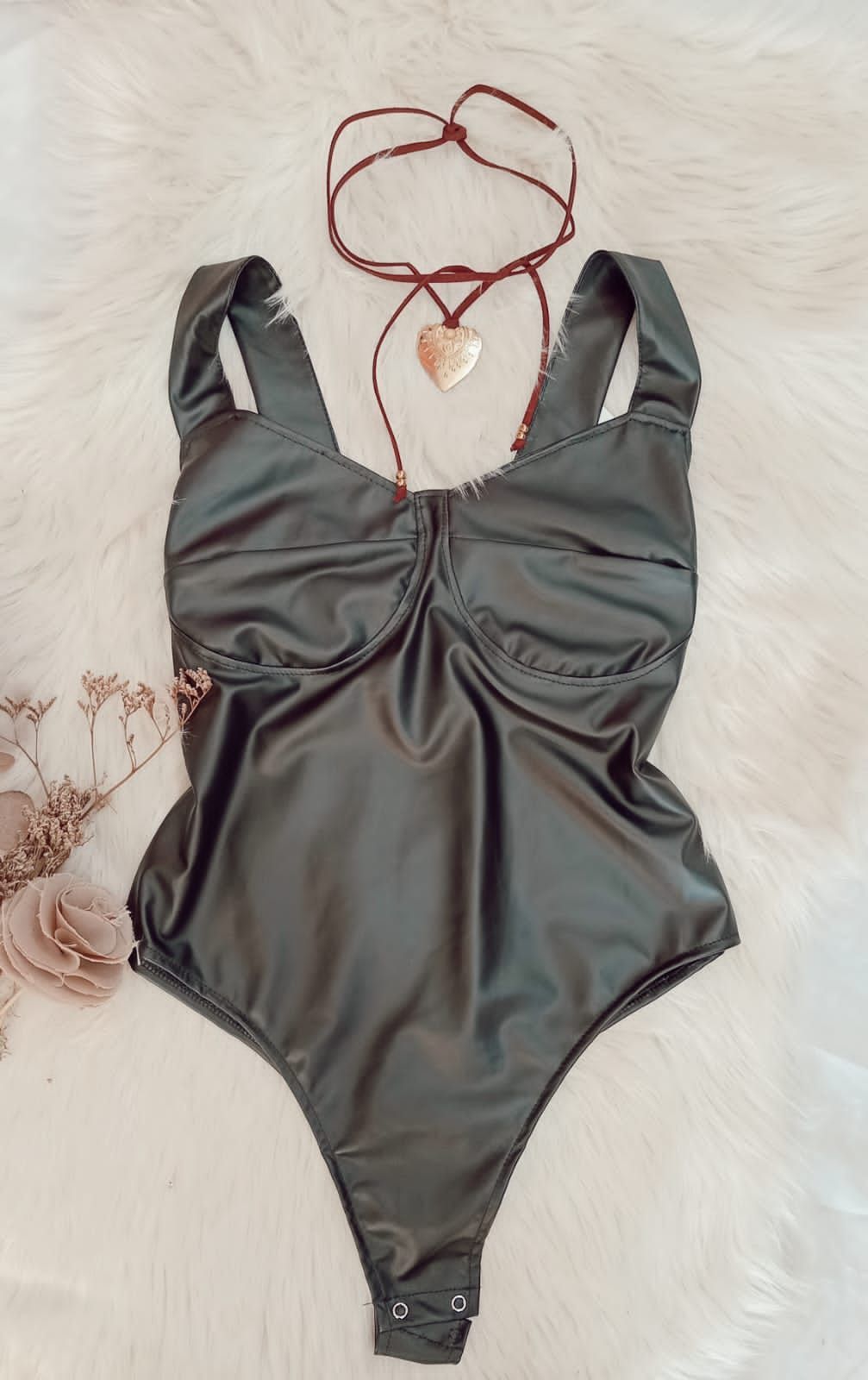Un traje está sentado sobre una manta blanca al lado de un collar.