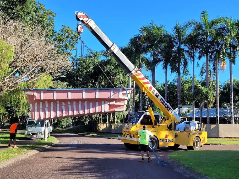 A Crane Is Lifting A Swimming Pool In A Driveway — Burton Group In Ciccone, NT