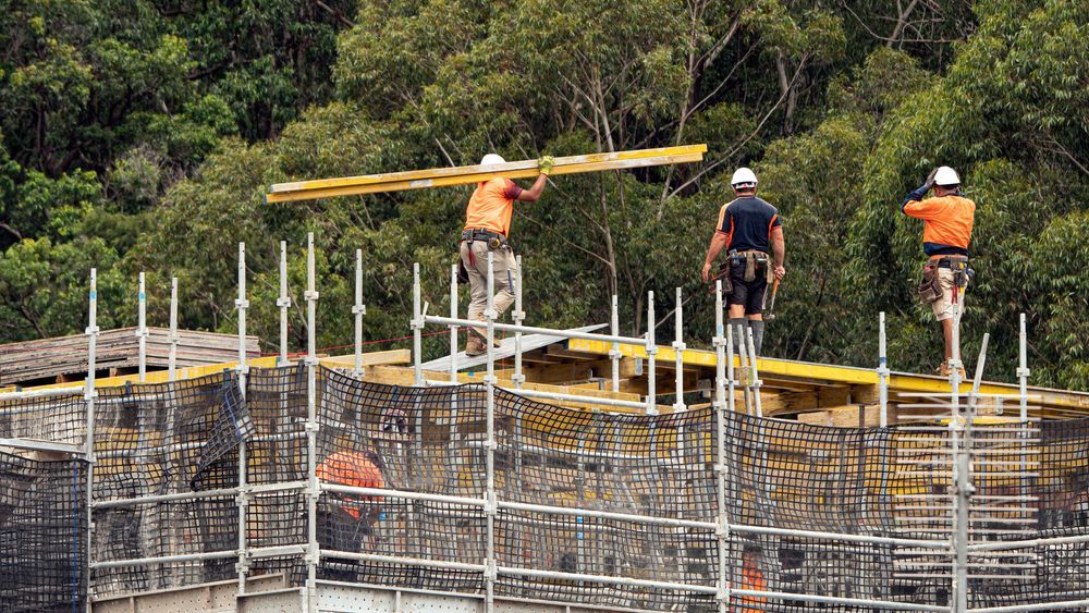 A Construction Worker Is Walking On A Construction Site — Burton Group In Ciccone, NT